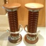 A pair of bar stools assembled from glazed ceramic and metal coils from a power station, with