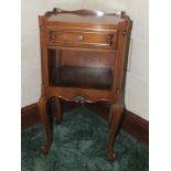 A French mahogany bedside cupboard with gallery top, over single drawer and open shelf, raised on