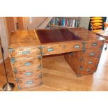 A 20th century campaign design twin pedestal writing desk, figured timber, probably elm, the top
