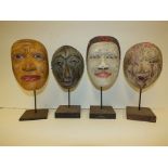 Four various Balinese painted masks with bases
