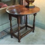 A late 17th century oak and elm side table, the oval top with drop flaps, plain rectangular