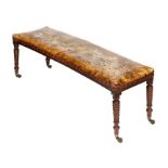 A Regency period, mahogany framed concave window seat, with hide studded upholstered top, raised