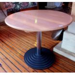 A contemporary dining table, having circular top on a central column, with stepped circular base,