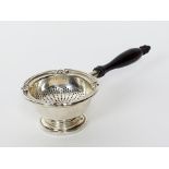 A silver tea strainer and stand, import mark for Garrard & Co. London, the pierced strainer of