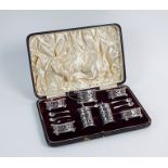 A cased Victorian seven piece silver condiment set, Walker & Hall, Birmingham 1897 & 1899, each