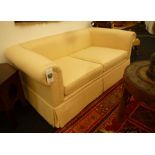 A modern two seater low sofa, covered in a cream trellis pattern material, 168cm wide