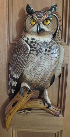 A late 20th century carved wood and painted owl, in low relief, wall mounting, depicted perched on a