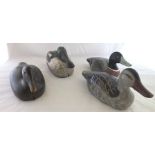 An early to mid 20th century carved and painted wood decoy duck, with glass eyes, securing wire