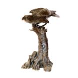 A Japanese Meiji period bronze eagle, mounted on a tree stump base, well modelled with brown patina,