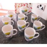 A teapot and eight large mugs, decorated in the Sanderson "Dandelion Clock" pattern, produced by "