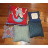 A quantity of scatter cushions, includes one with red panel having mermaid design, bearing the