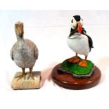 Two model birds, a puffin on wooden base and a dodo on book design base