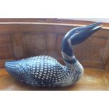 "Kach" - A carved wood and polychrome model of a loon goose, white spotted black ground, signed to