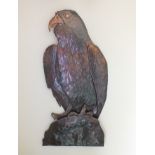 An embossed sheet copper bird of prey, on a rockwork base, 70cm high