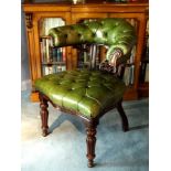 A William IV/early Victorian mahogany elbow library chair, upholstered with green hide, on turned