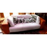 A contemporary sofa, having weave back frame with cream fabric upholstered seat and back, with