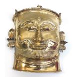 A late 19th century brass Indian mask, depicting a man's head wearing ear decorations in the form of