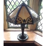 A Tiffany style table lamp, cast and painted metal umbrella shade with bell husk motifs and acanthus