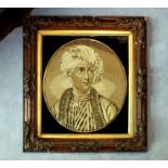 A Victorian needlework panel depicting the bust figure of a Turk, oval with verre eglomise front and