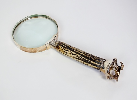 A white metal and stag horn magnifying glass, the horn handle with white metal terminal mounted with