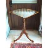 A Regency rosewood tripod games table, the crossbanded square top with rounded corners and chequer