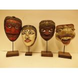 Four various Balinese painted masks with bases to include a 'Topeng' example