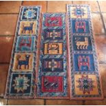 A pair of flat weave wall hangings, the square fields containing stylized floral and animal