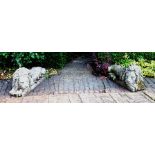 A pair of stone lions after the antique in recumbent poses on rectangular bases, 50cm high, 115cm