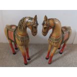 A pair of 20th century carved wood and painted horses, possibly Indian, gilded and decorated with