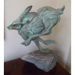 Pierre Diamantopoulo A bronzed steel sculpture of a running mad march hare, supported on a slate