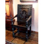 A mid 17th century oak elbow chair, the rectangular back with chip carved frame, foliate strap