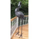 A pair of late 20th century bronze cranes, one with beak open and head pointed aloft, 224cm high,