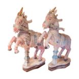 A pair of 19th century Indian carved wood rearing horses, polychrome painted on a white ground, with