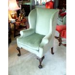 A mid 18th century wing back elbow chair, the high rectangular back, scroll over swept front arms,