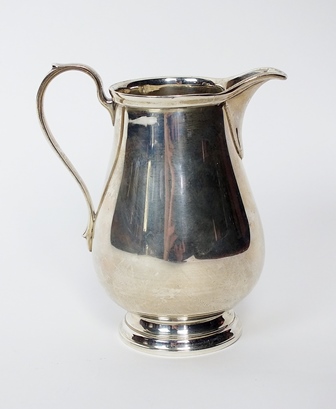 A Tiffany & Co sterling silver cream jug, of plain polished baluster form with scroll handle,