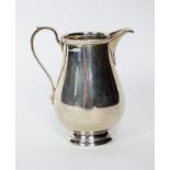 A Tiffany & Co sterling silver cream jug, of plain polished baluster form with scroll handle,