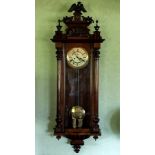 A 19th century walnut Vienna twin weight Regulator wall clock, the arched pediment with carved