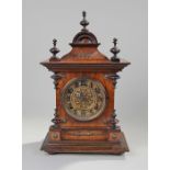 Early 20th Century German walnut mantel clock, the three finial top with arch above a gilt dial