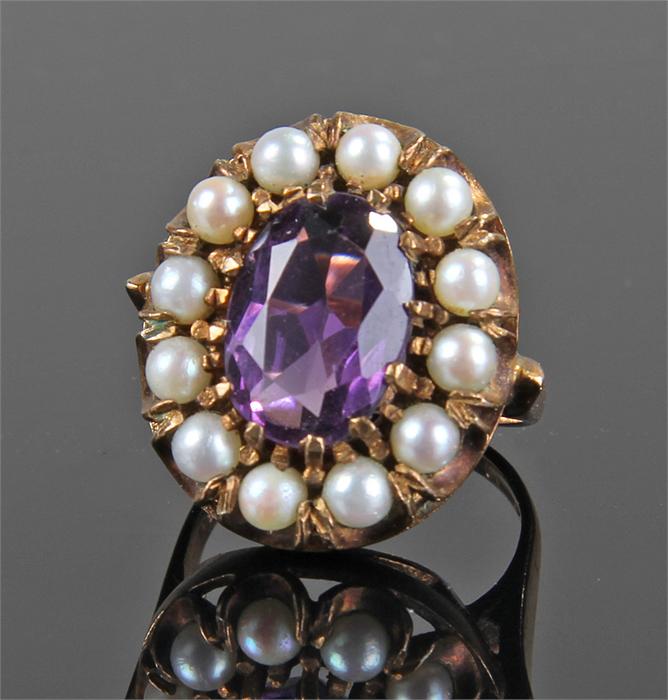 Yellow metal stone and pearl set ring, with central purple stone, flanked with pearls, ring size P