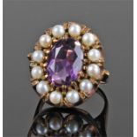 Yellow metal stone and pearl set ring, with central purple stone, flanked with pearls, ring size P