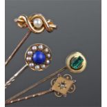 Four stick pins, to include a 15 carat gold pearl example, a green stone example and two Victorian