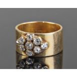 18 carat gold diamond set ring, the wide band set with nine old brilliant cut diamonds, ring size K