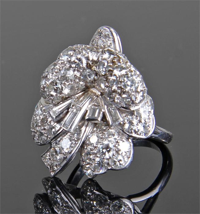 Impressive Platinum and diamond set ring, in the form of ribbons and flowers, with central