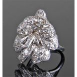 Impressive Platinum and diamond set ring, in the form of ribbons and flowers, with central