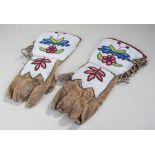 Late 19th Century Native American beaded gauntlets, with a a multi coloured flower and leaf pattern,