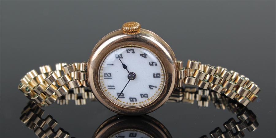 Ladies 9 carat gold wristwatch, the white enamel dial with Arabic hours, rolled gold strap, case