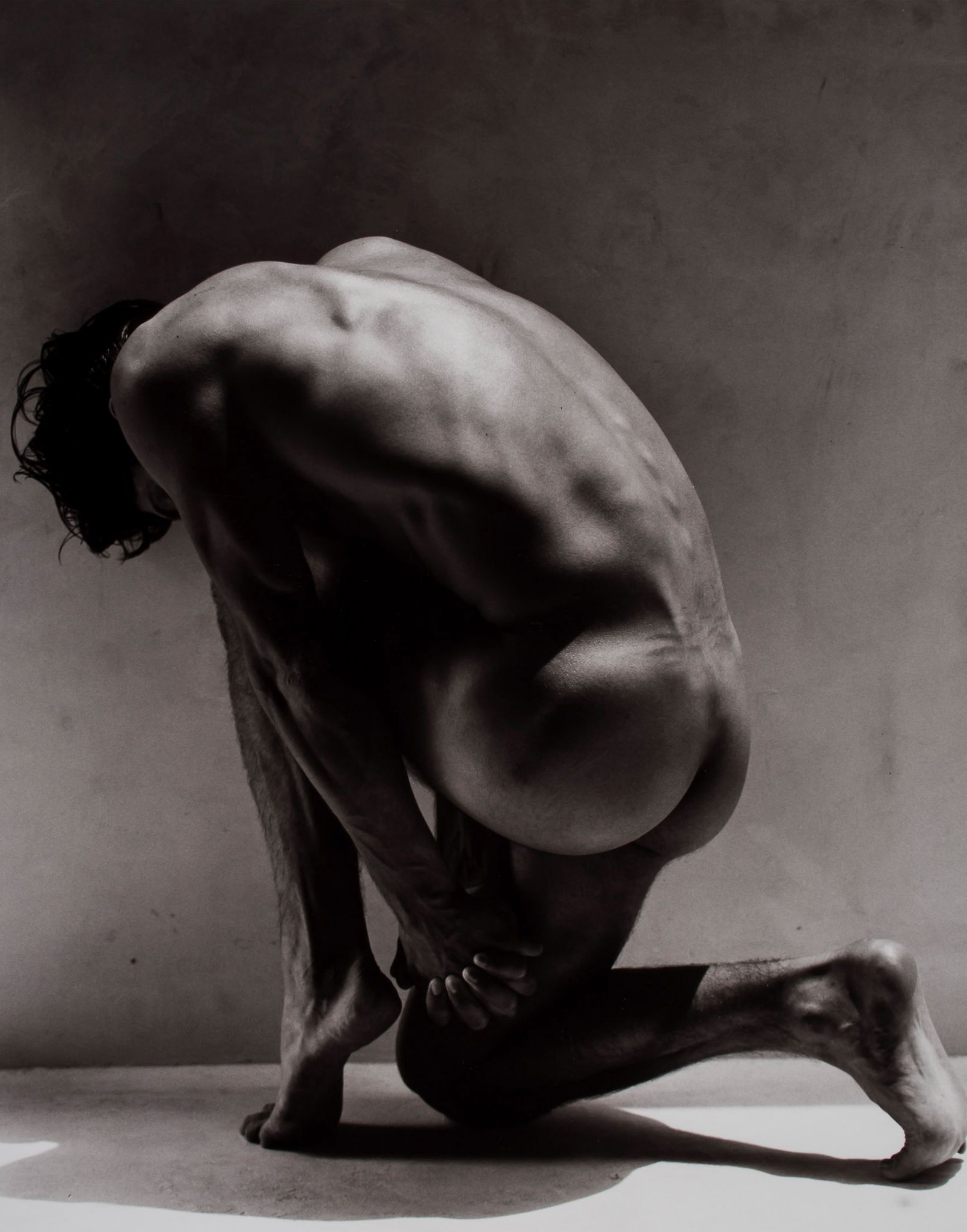 Greg Gorman (b.1949) - Tony Kneeling, 1988 Gelatin silver print, flush mounted to card, signed,