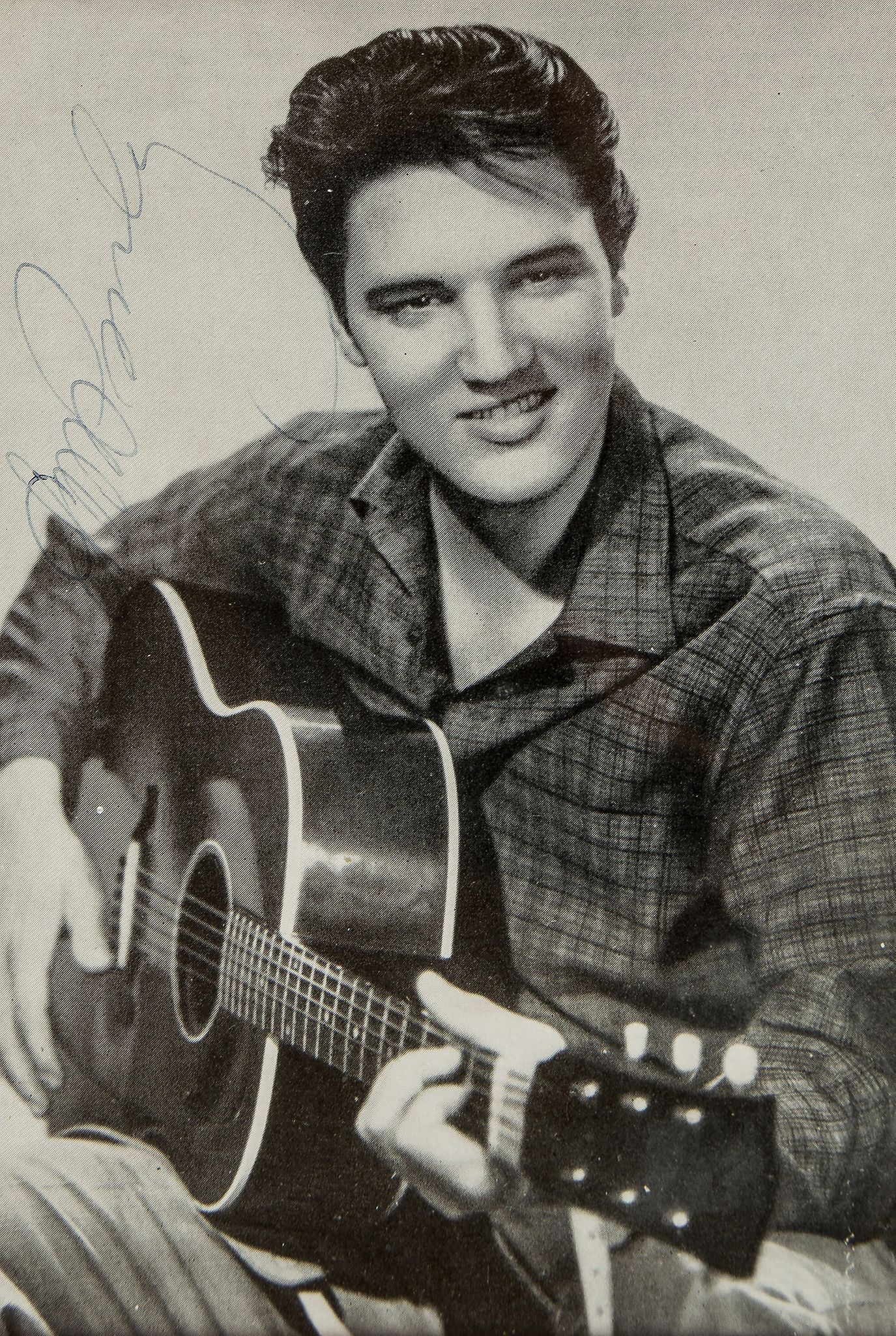 PRESLEY, ELVIS - Glossy black and white photograph of the singer holding a guitar... Glossy black