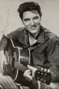 PRESLEY, ELVIS - Glossy black and white photograph of the singer holding a guitar... Glossy black