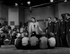 PRESLEY, ELVIS - Black and white photograph of Elvis Presley singing in front of a... Black and